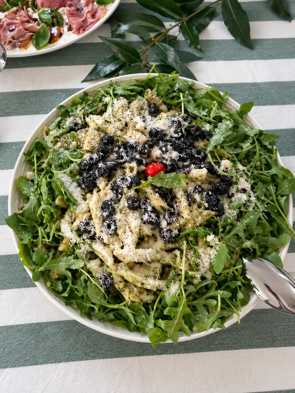 Salade de pâtes au pesto, roquette, olives noires, tomates séchées et parmesan